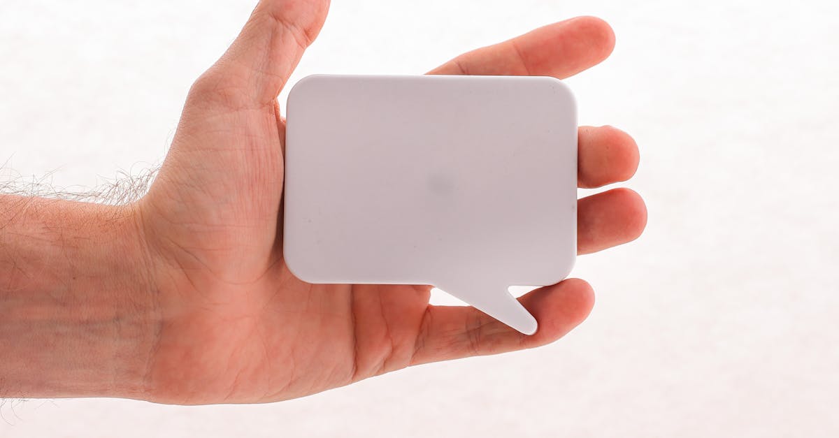 A hand holding a blank white speech bubble sticker, perfect for mockups or conceptual designs.
